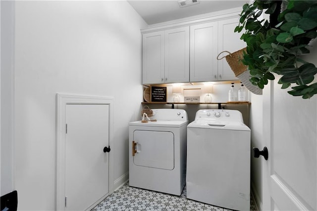 washroom featuring cabinet space, visible vents, washer and dryer, and light floors