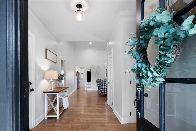 entrance foyer featuring ornamental molding, baseboards, and wood finished floors