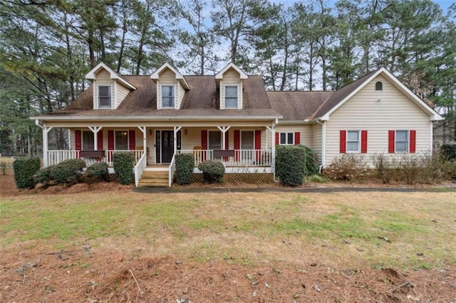 cape cod home with covered porch and a front lawn