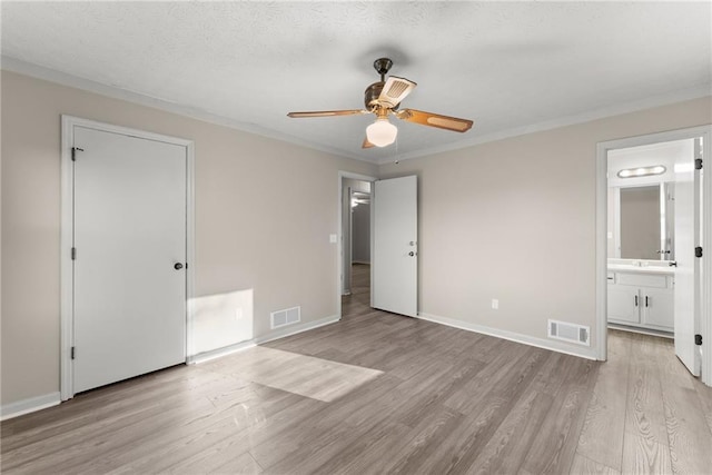 unfurnished bedroom with ornamental molding, ceiling fan, light wood-type flooring, and ensuite bath