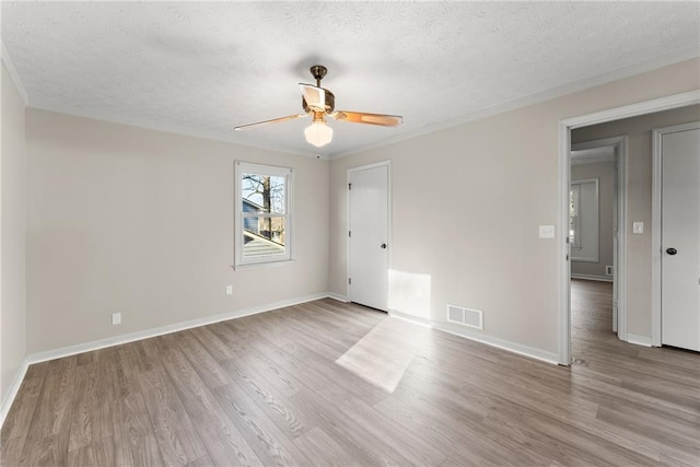 unfurnished room with crown molding, ceiling fan, light hardwood / wood-style flooring, and a textured ceiling