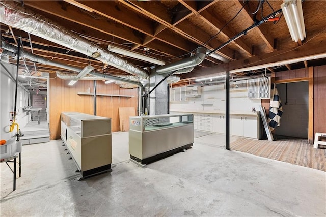 basement featuring wood walls