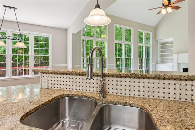 details featuring a sink, ceiling fan, decorative light fixtures, and light stone countertops