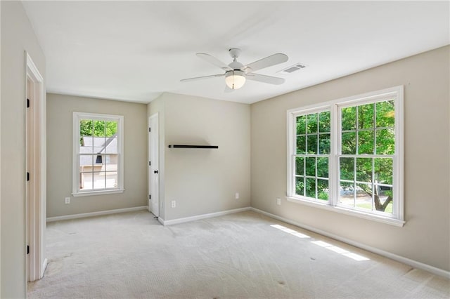 spare room featuring a wealth of natural light, carpet, and visible vents