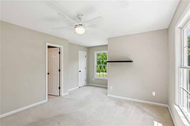 unfurnished bedroom featuring baseboards, a ceiling fan, and light carpet
