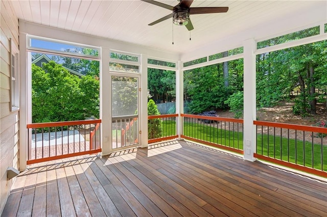 unfurnished sunroom with ceiling fan