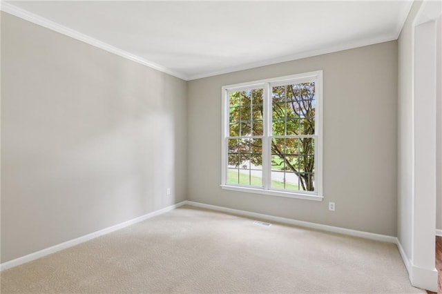 empty room featuring baseboards, ornamental molding, visible vents, and light colored carpet