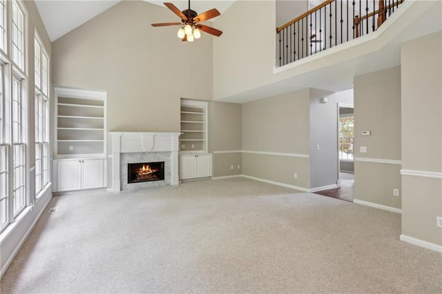 unfurnished living room with high vaulted ceiling, a wealth of natural light, ceiling fan, and a fireplace