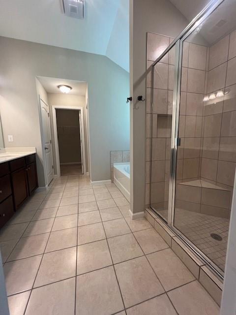 239 Lenore Ct, Hiram, GA 30141 - bathroom featuring tile patterned floors, a garden tub, vanity, a shower stall, and vaulted ceiling