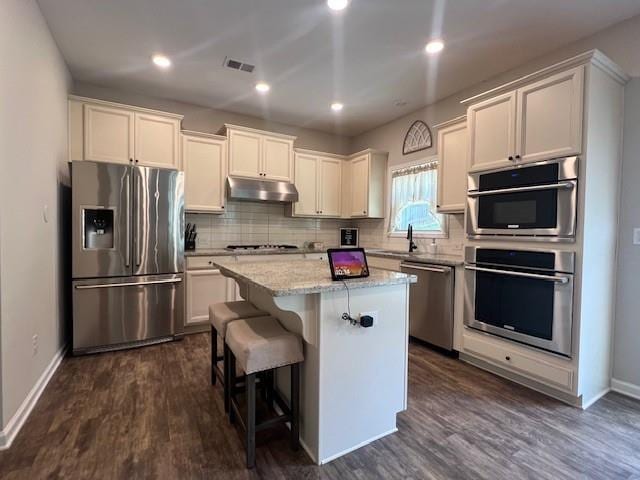 239 Lenore Ct, Hiram, GA 30141 - kitchen featuring stainless steel appliances, under cabinet range hood, a kitchen island, backsplash, and recessed lighting