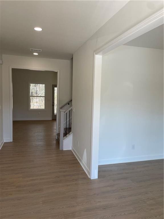 corridor featuring recessed lighting, visible vents, baseboards, and dark wood-style flooring