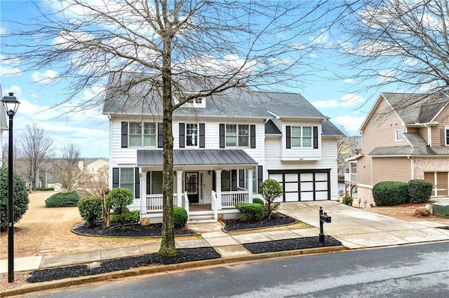 view of front of property featuring a garage, driveway, and a porch