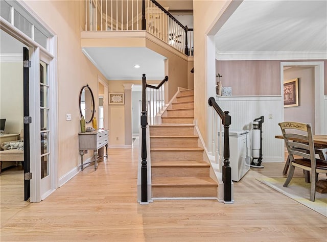 staircase with crown molding, baseboards, and wood finished floors