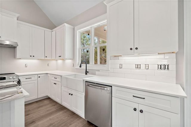 kitchen featuring stove, stainless steel dishwasher, vaulted ceiling, sink, and white cabinetry