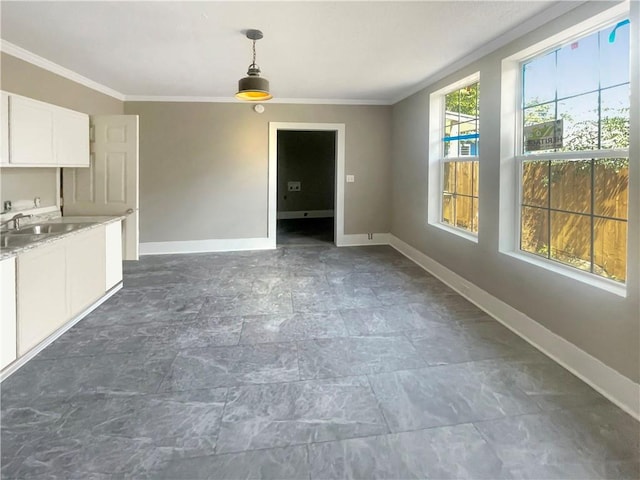 unfurnished living room with ornamental molding and sink