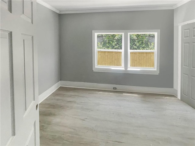 empty room featuring light hardwood / wood-style floors and crown molding