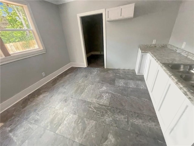 kitchen with light stone countertops and white cabinets