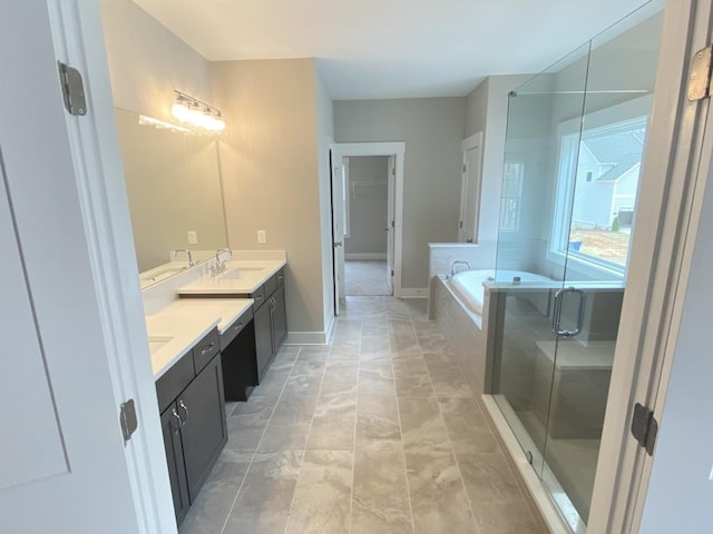 full bathroom featuring double vanity, a sink, a walk in closet, a shower stall, and a bath