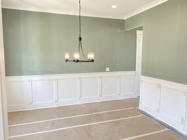 empty room featuring a chandelier and crown molding