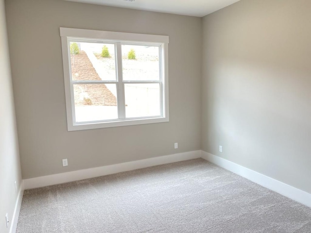 empty room featuring carpet floors, plenty of natural light, and baseboards