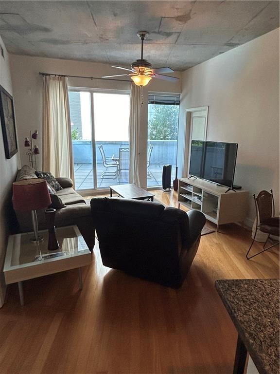 living room featuring ceiling fan and light wood-type flooring