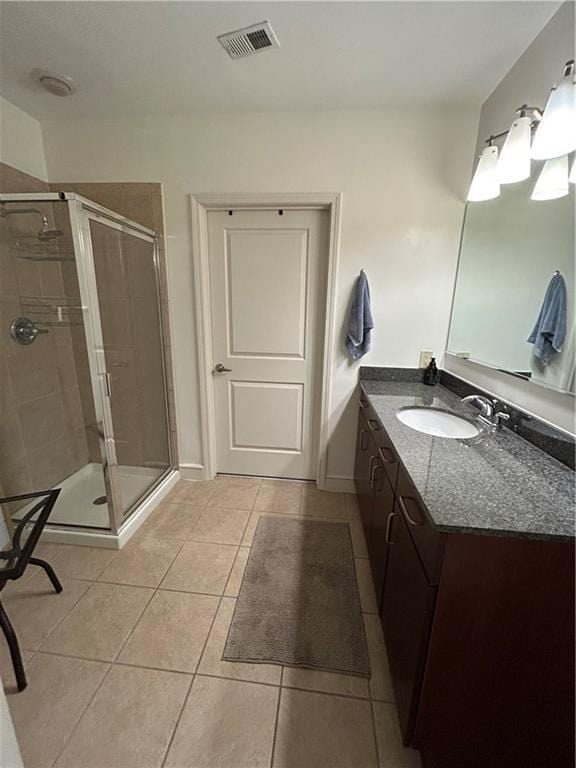 bathroom with tile patterned floors, vanity, and a shower with shower door