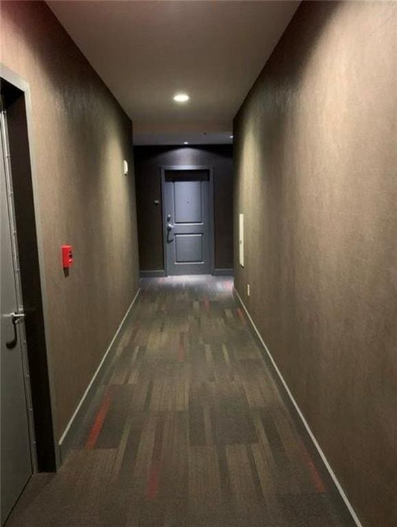 corridor featuring dark colored carpet