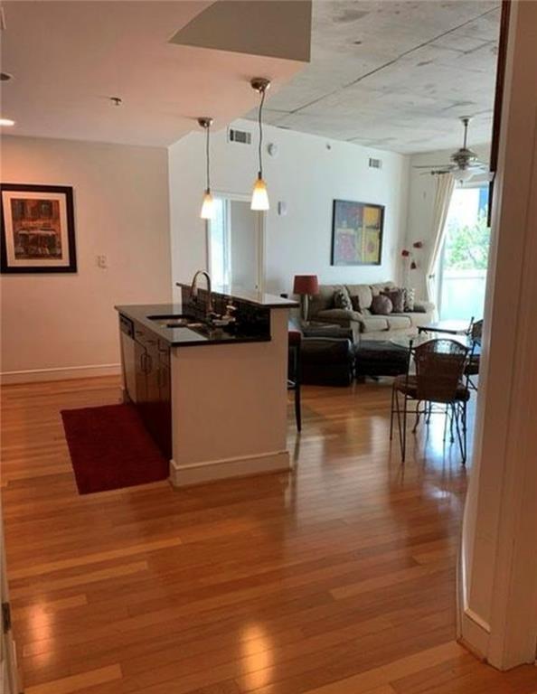 kitchen with sink, decorative light fixtures, light wood-type flooring, stainless steel dishwasher, and ceiling fan