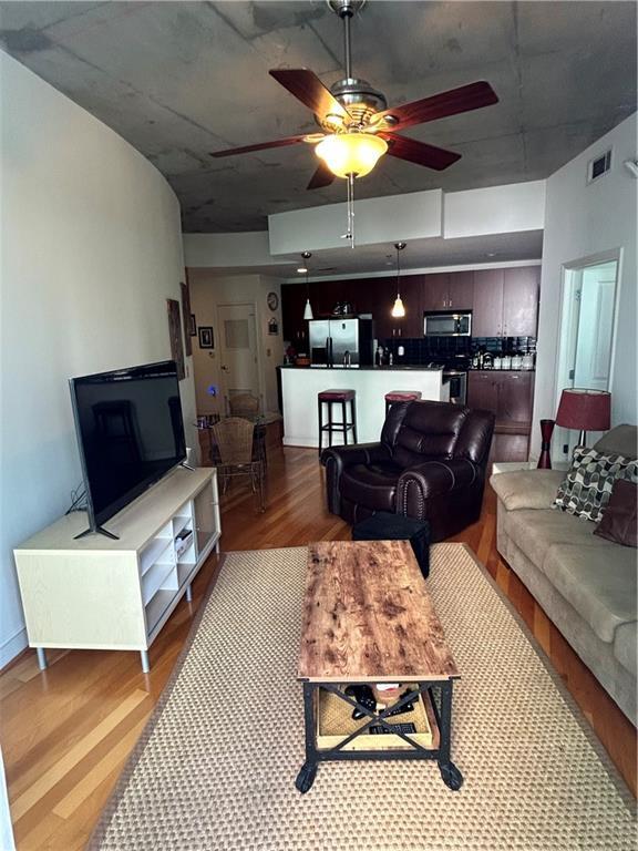 living room featuring ceiling fan and light wood-type flooring