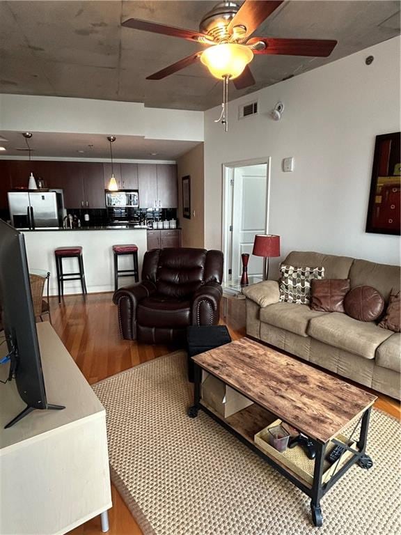 living room with light hardwood / wood-style floors and ceiling fan