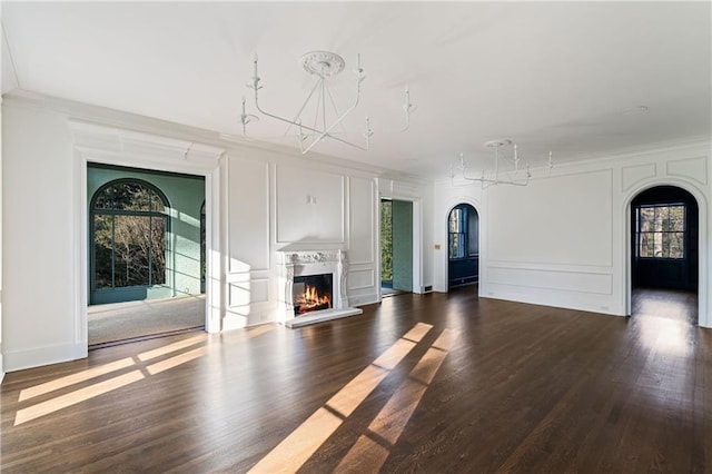 3051 Habersham Rd NW, Atlanta, GA 30305 - unfurnished living room with arched walkways, ornamental molding, a decorative wall, and a glass covered fireplace