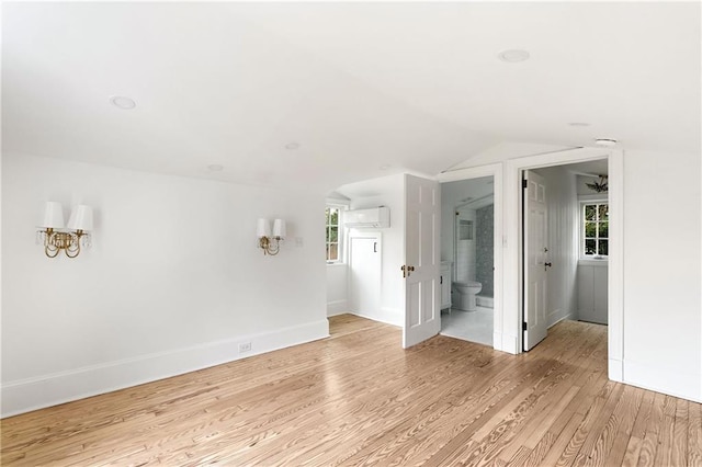 3051 Habersham Rd NW, Atlanta, GA 30305 - spare room with lofted ceiling, a wealth of natural light, a wall unit AC, and light wood-style floors
