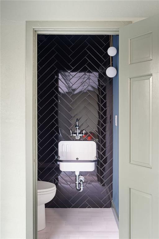 3051 Habersham Rd NW, Atlanta, GA 30305 - bathroom with tile walls, a sink, and toilet