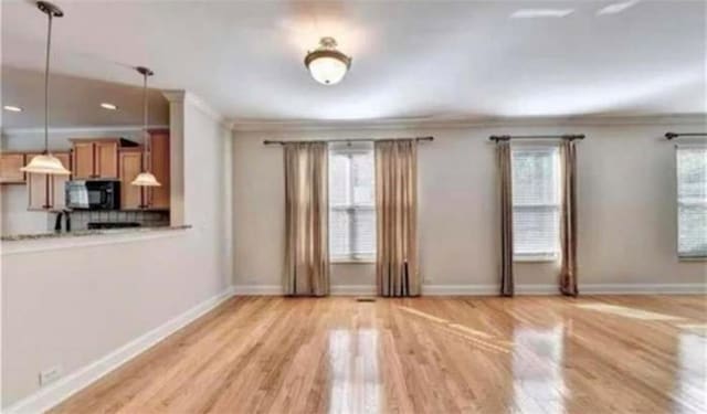 interior space with plenty of natural light, light wood-type flooring, and ornamental molding