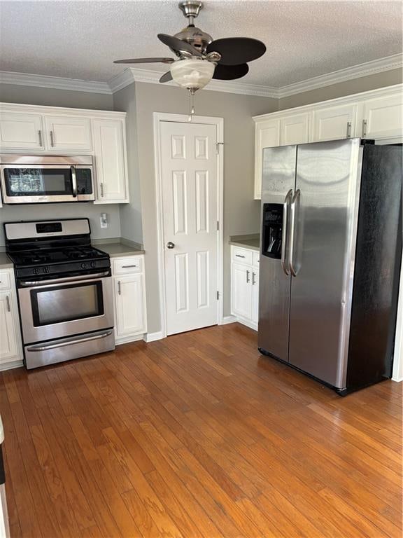 kitchen featuring white cabinetry, hardwood / wood-style floors, a textured ceiling, and appliances with stainless steel finishes