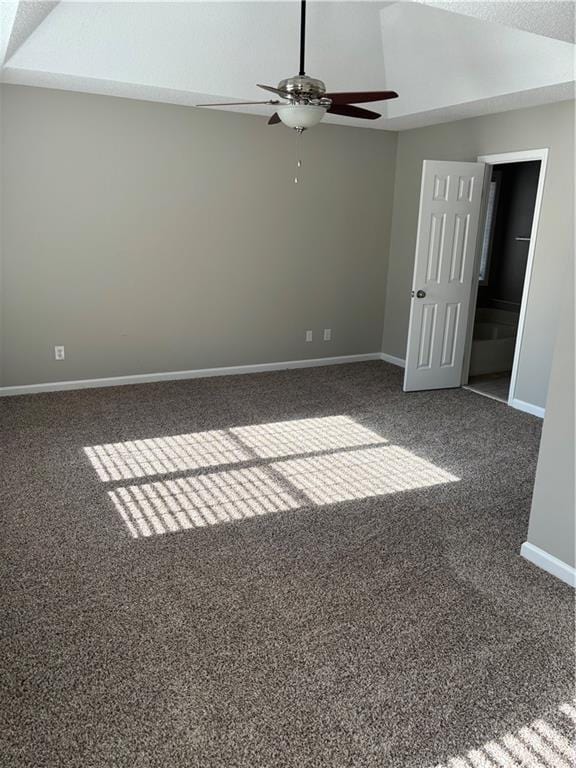 empty room with ceiling fan and dark carpet