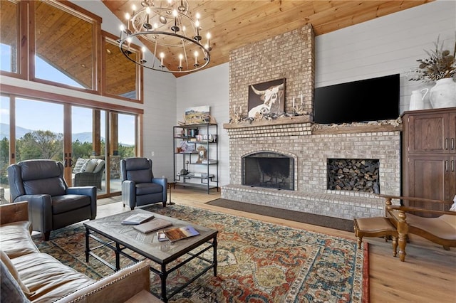 living room featuring wooden ceiling, a chandelier, high vaulted ceiling, light hardwood / wood-style flooring, and a fireplace