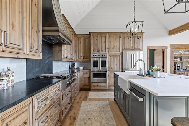 kitchen featuring appliances with stainless steel finishes, tasteful backsplash, light hardwood / wood-style floors, custom exhaust hood, and sink