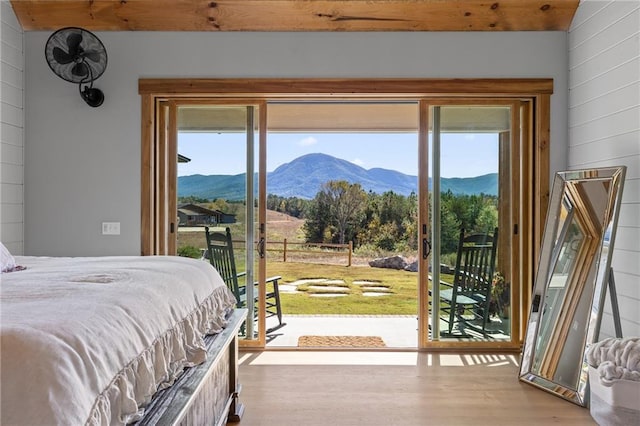 bedroom featuring access to outside, a mountain view, and light hardwood / wood-style floors