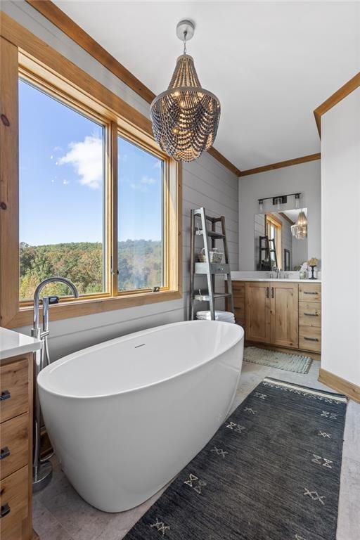 bathroom with vanity, tile floors, a bath to relax in, and ornamental molding