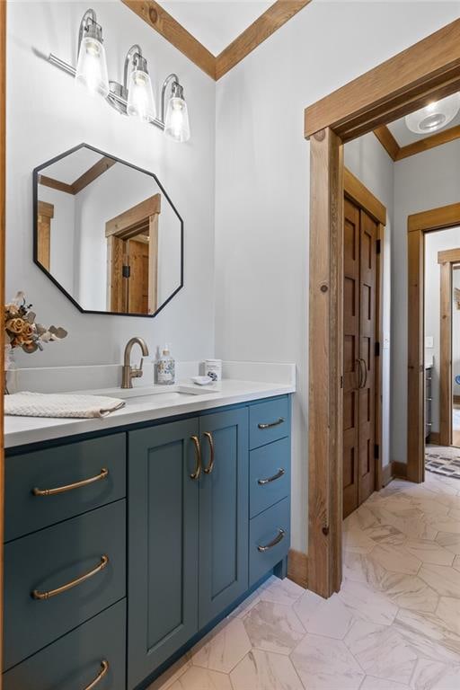 bathroom featuring oversized vanity, ornamental molding, tile floors, and dual sinks