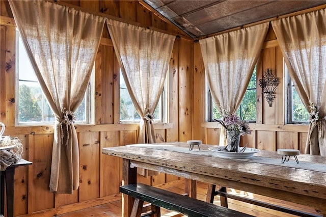 dining area featuring a wealth of natural light, wood ceiling, and wooden walls