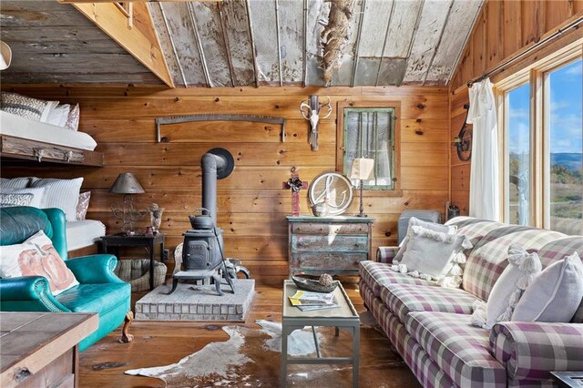 living room featuring dark wood-type flooring, lofted ceiling, wood ceiling, and a wood stove