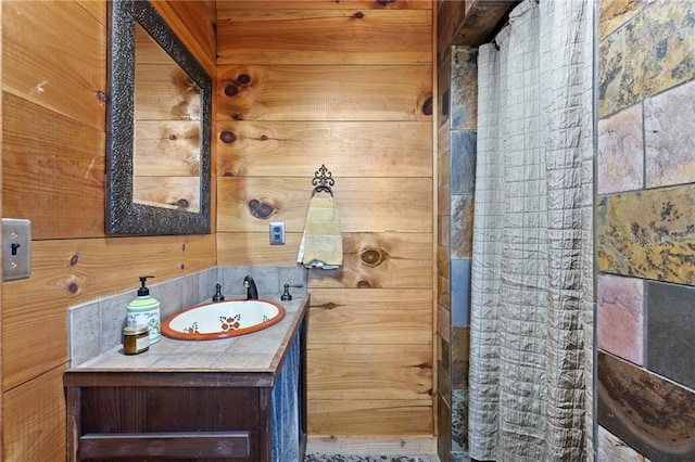 bathroom featuring vanity and wood walls