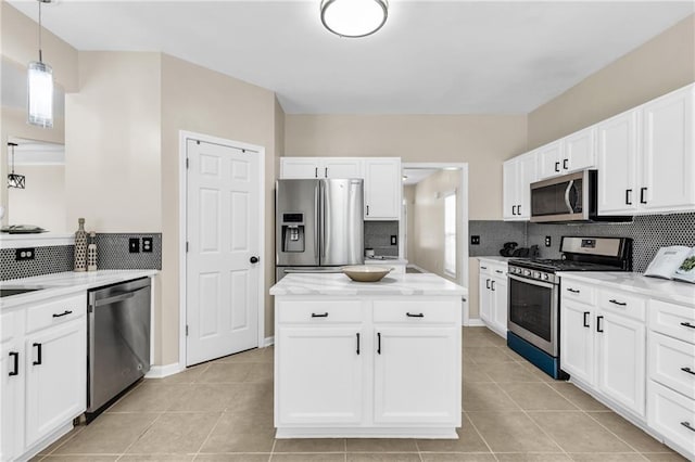 kitchen featuring stainless steel appliances, decorative backsplash, and white cabinets