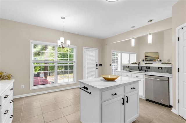 kitchen with dishwasher, a sink, a chandelier, light tile patterned floors, and white cabinets