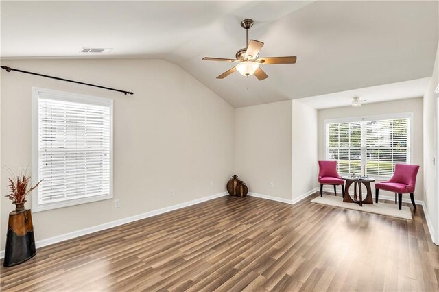 sitting room with ceiling fan, wood finished floors, vaulted ceiling, and baseboards