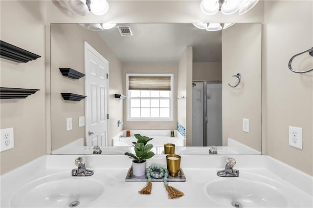 bathroom with double vanity, a stall shower, and a garden tub