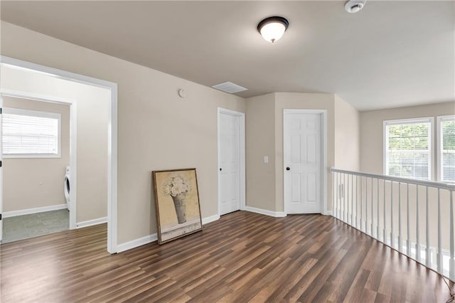 additional living space featuring baseboards, wood finished floors, and washer / dryer