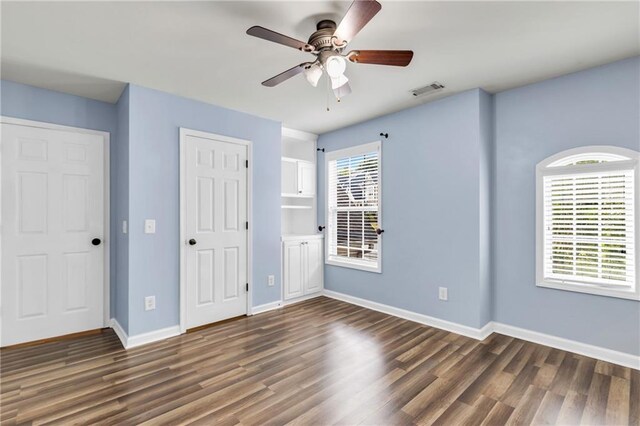 unfurnished bedroom with dark wood-type flooring, baseboards, and ceiling fan